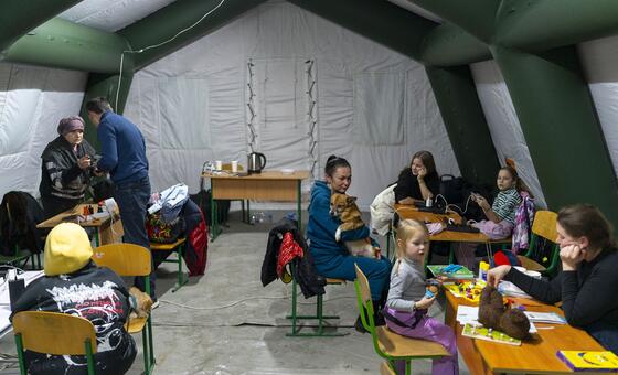 عائلات تبحث عن الدفء والدعم داخل خيمة متنقلة خلال انقطاع الكهرباء في كييف، أوكرانيا.